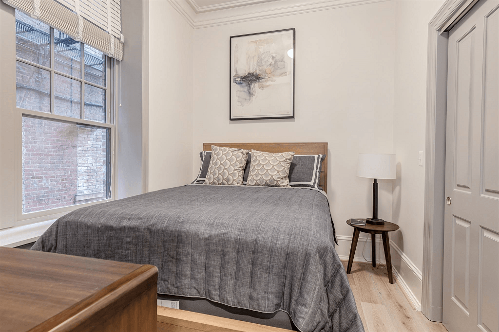 a bedroom with a bed and a large window